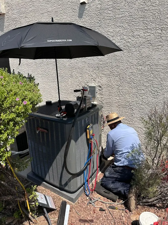 HVAC technician performing outdoor AC maintenance in Malden
